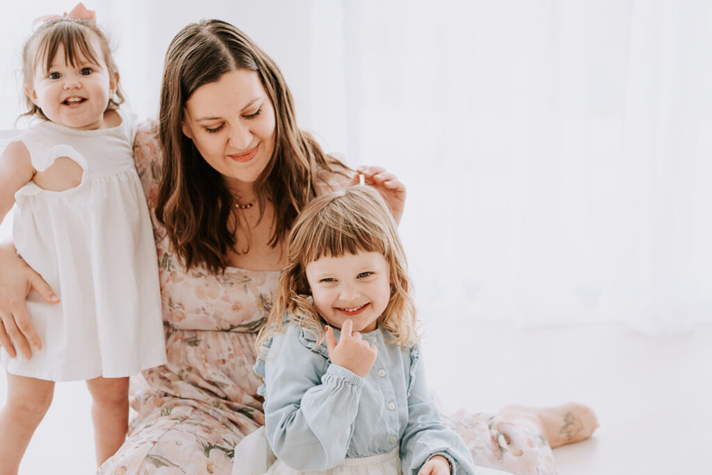 A north texas mom holding her daughters during a studio photography session in roanoke texas serving moms and capturing motherhood