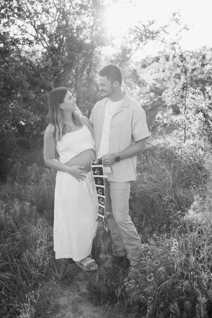 Expecting couple at 20 weeks pregnant posing for maternity photography session at Murrell Park Flower Mound Texas